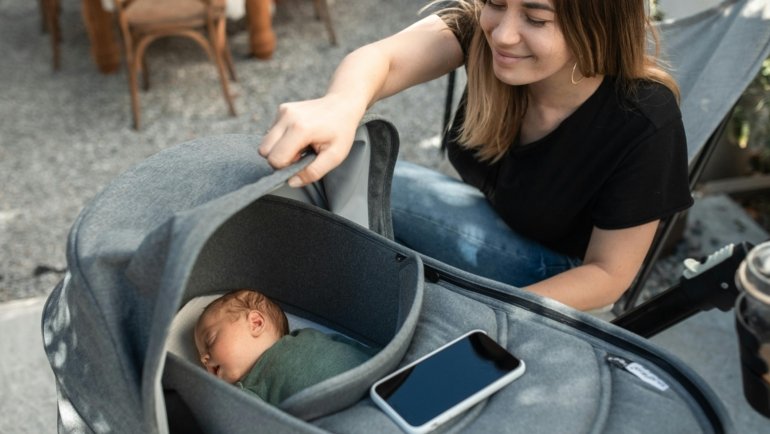Active parents navigating a park with a modern baby travel system, featuring an infant car seat seamlessly attached to a stroller, showcasing convenience for safe and easy baby travel.
