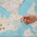 A traveler's collection of rare gold coins from different countries displayed on a vintage world map with a compass, symbolizing numismatic adventure, historical discovery, and valuable investment.