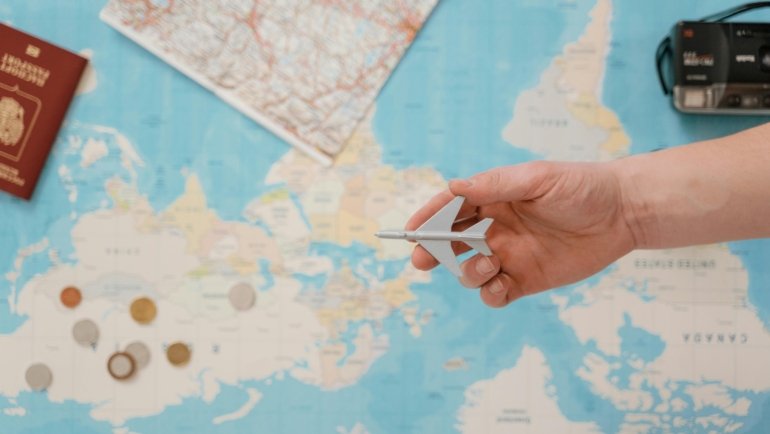 A traveler's collection of rare gold coins from different countries displayed on a vintage world map with a compass, symbolizing numismatic adventure, historical discovery, and valuable investment.