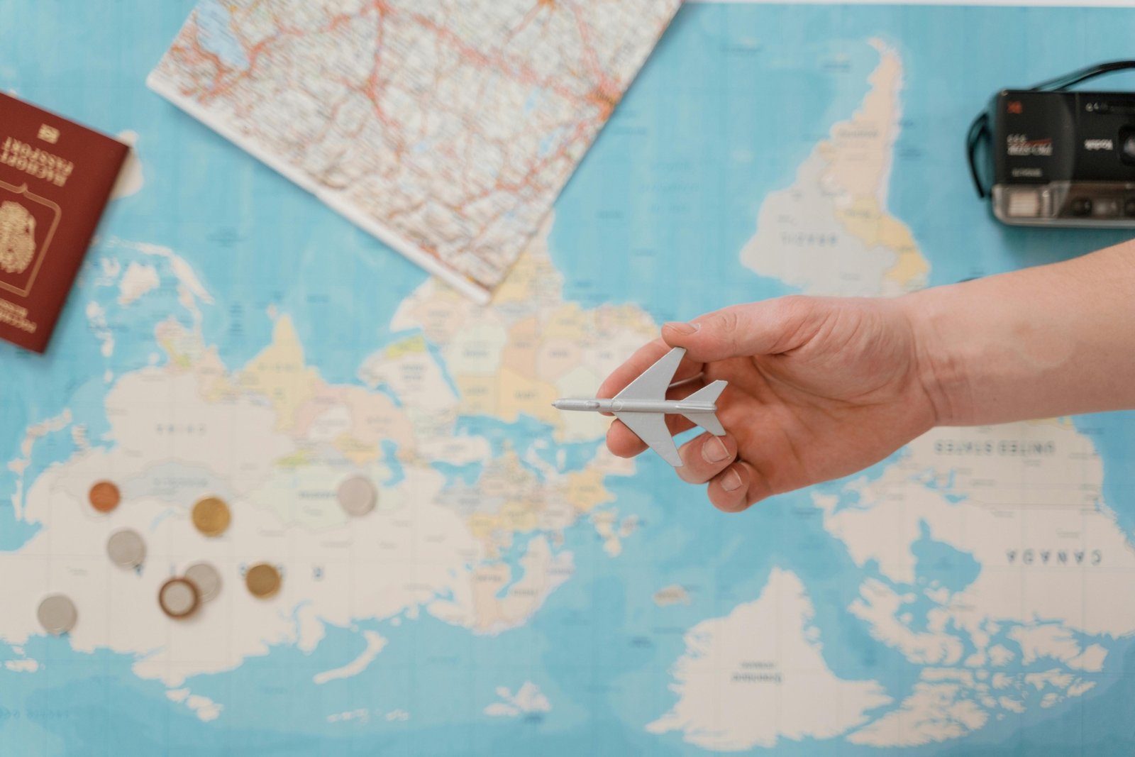 A traveler's collection of rare gold coins from different countries displayed on a vintage world map with a compass, symbolizing numismatic adventure, historical discovery, and valuable investment.