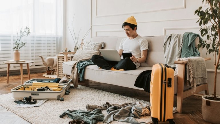 Stylish man packing a travel size men's cologne into his carry-on, emphasizing TSA-friendly fragrance for modern jet-setters and confident travel.