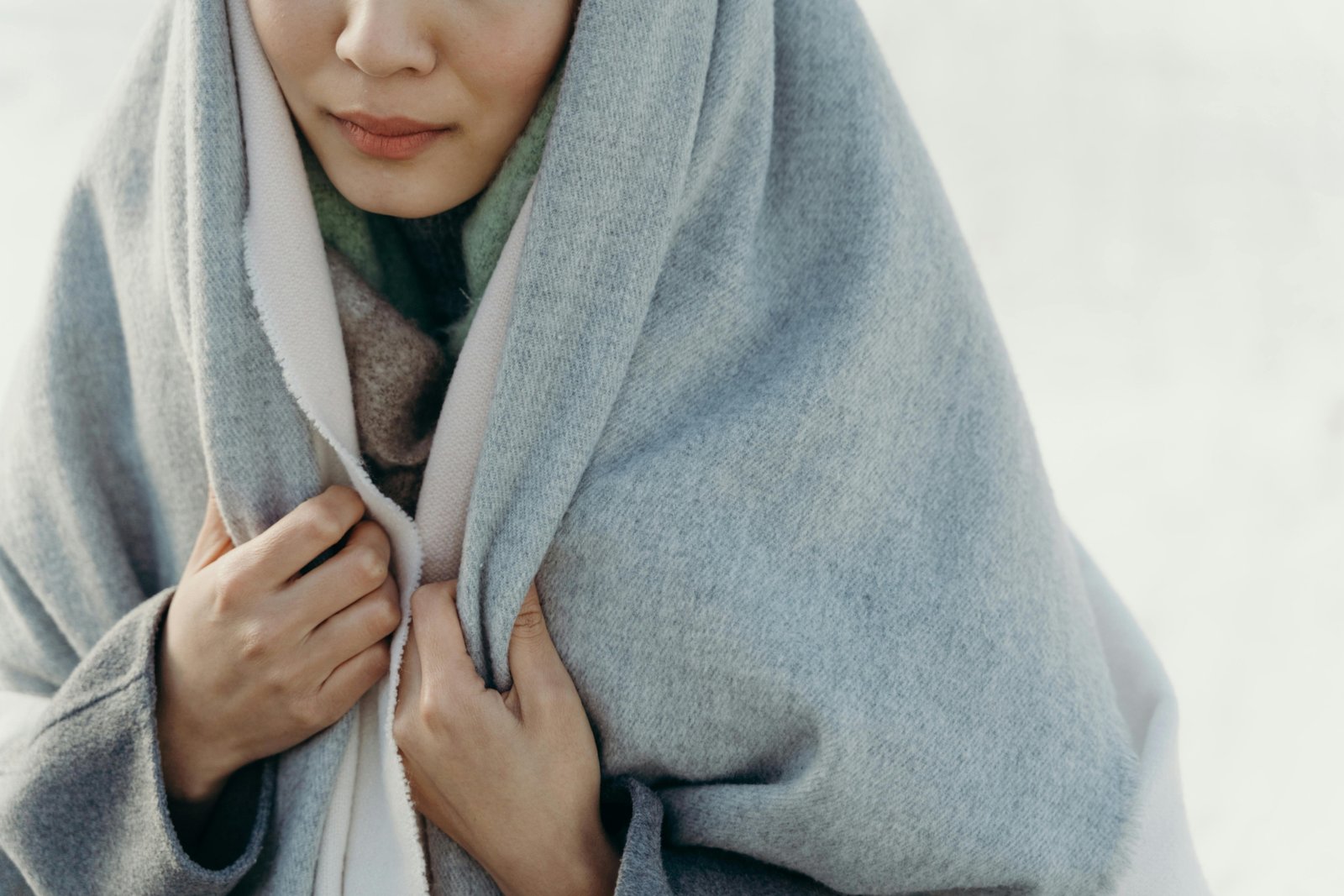 Luxury cashmere travel wrap offering comfort and style to an elegant female traveler on an airplane, showcasing its versatility as a shawl or blanket.