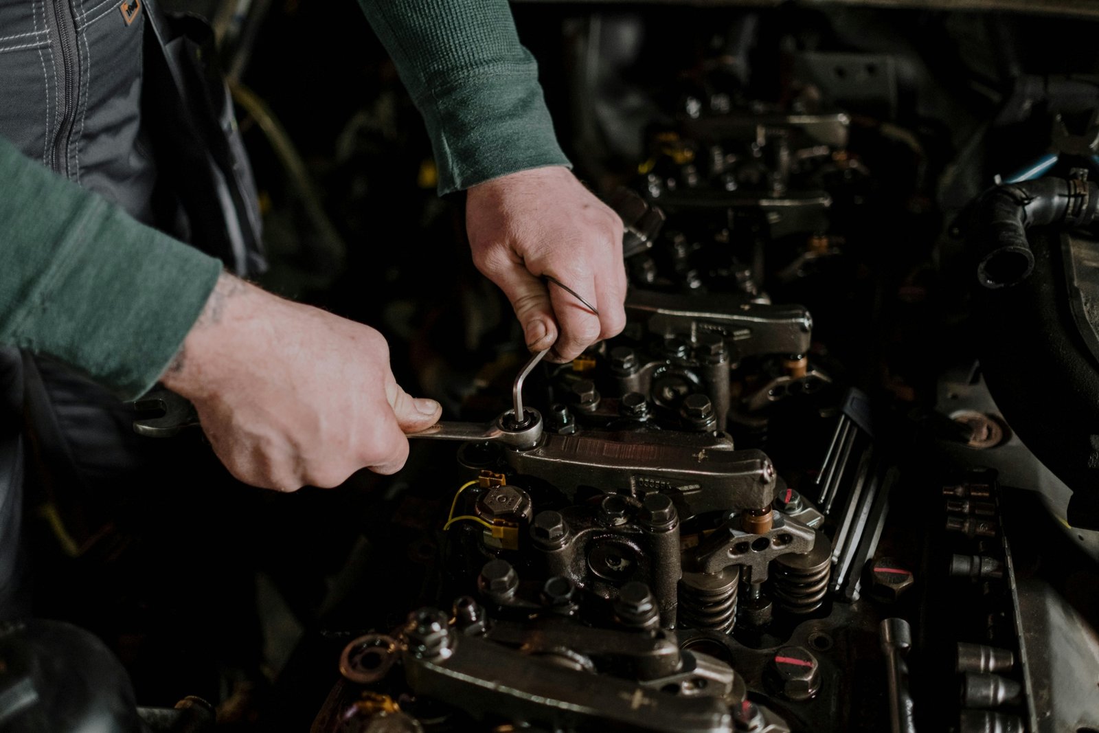 Close-up of hands performing Concept 2 rowing machine travelling pulley assembly maintenance, cleaning dust and inspecting for smooth chain movement.