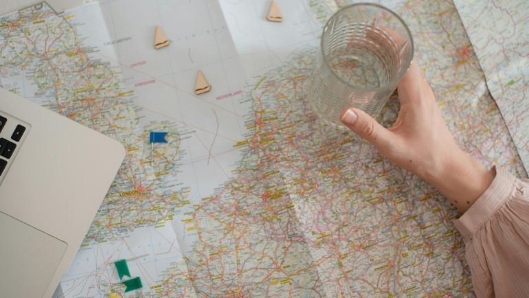 Entrepreneur planning travel agency business on a laptop with a world map, representing the strategic development and online launch of a new travel service.