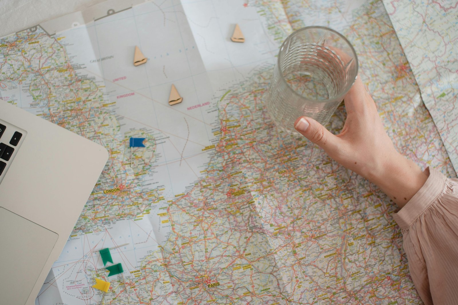 Entrepreneur planning travel agency business on a laptop with a world map, representing the strategic development and online launch of a new travel service.