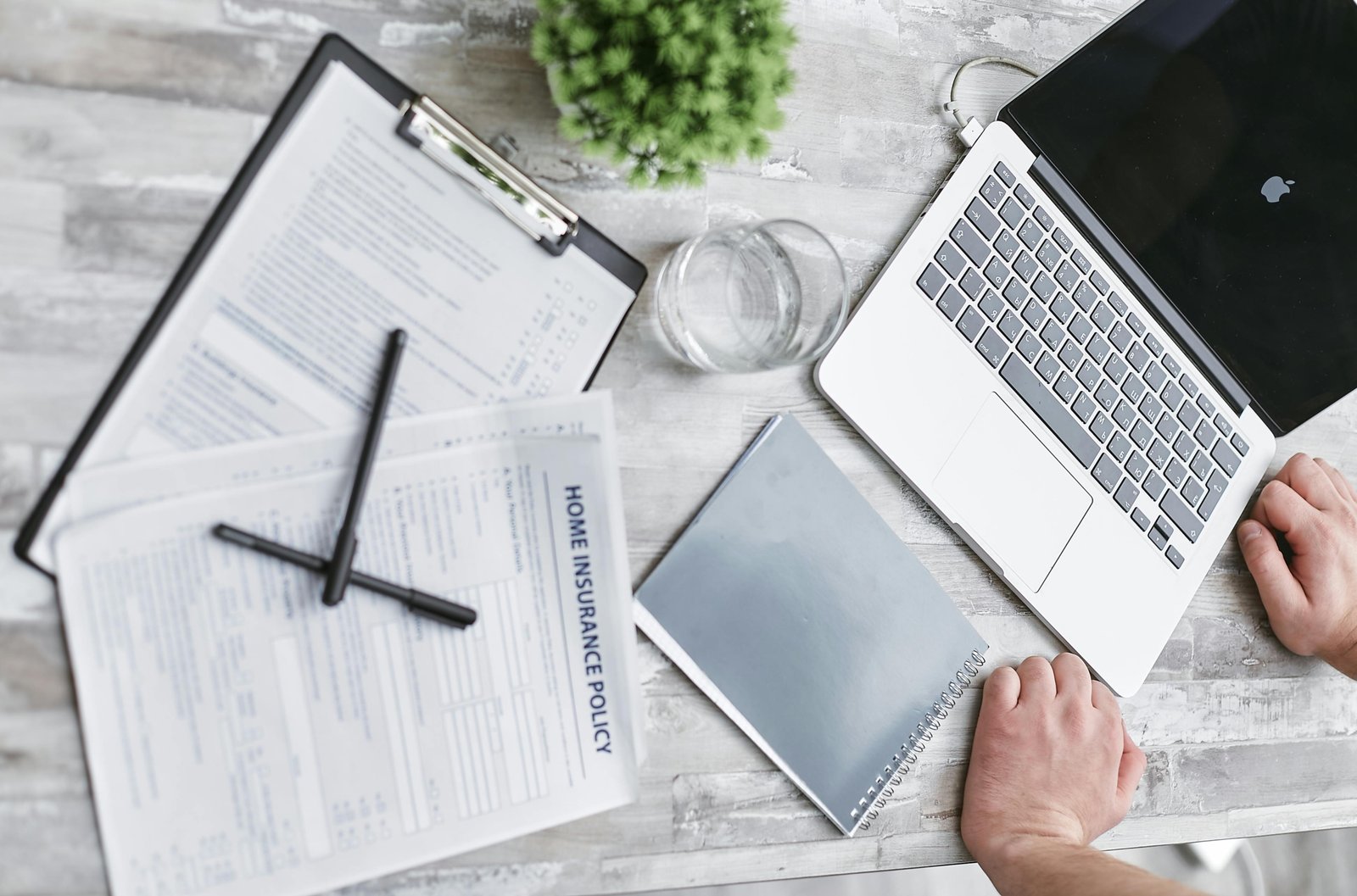 Aon travel claims guide: organized travel insurance documents, passport, and a digital claim form on a laptop, illustrating a smooth step-by-step filing process.