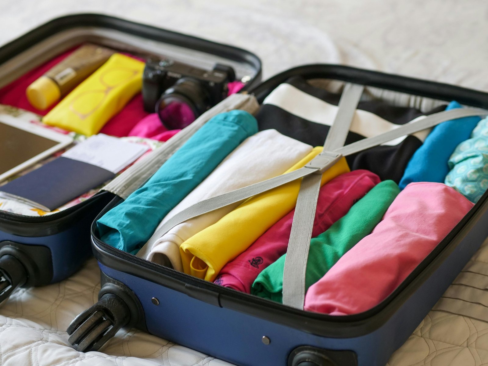 Organized travel size toiletries and essentials, including solid shampoo bars, refillable silicone bottles, and mini cosmetics, neatly packed into a carry-on suitcase for efficient, space-saving, and compliant travel.