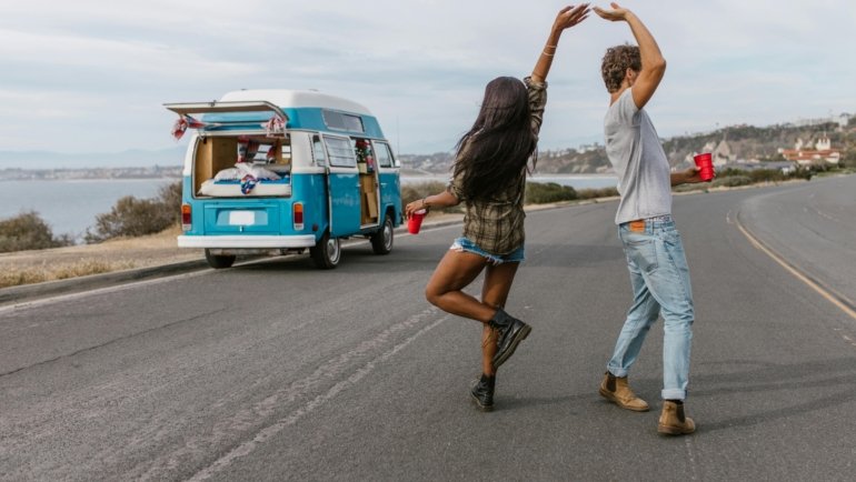 Happy traveler enjoying music on a scenic road trip, symbolizing the joy of travel songs and the freedom of adventure.