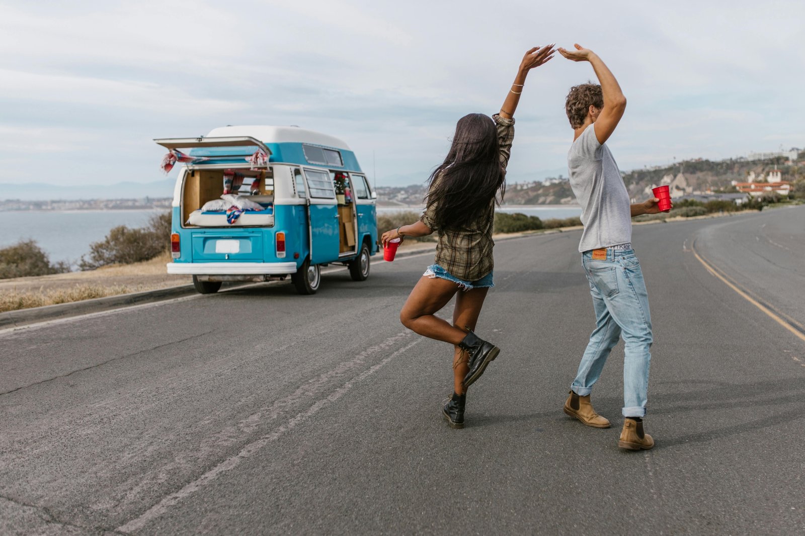 Happy traveler enjoying music on a scenic road trip, symbolizing the joy of travel songs and the freedom of adventure.
