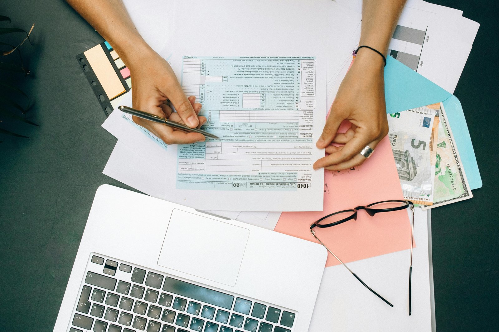 Person meticulously organizing business travel receipts and expense reports for a smooth travel fee settlement and reimbursement process.