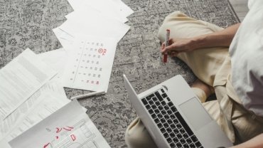Best day to book air travel to save money on flights, with a person planning their trip on a laptop and calendar.