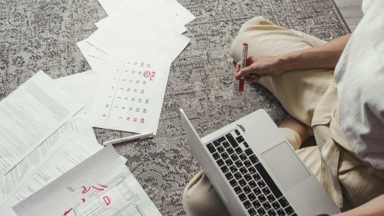 Best day to book air travel to save money on flights, with a person planning their trip on a laptop and calendar.