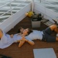 Happy couple enjoying a tropical sunset from a luxury cruise ship deck, reflecting the incredible value and exclusive perks of a Costco Travel cruise vacation.