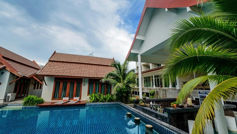Exterior view of a Travelers Inn Phoenix with a clean outdoor swimming pool, comfortable poolside seating, and a clear blue sky, ideal for budget-conscious road trippers and solo travelers looking for affordable accommodation in Arizona.
