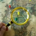 Person planning an affordable global adventure using Gate 1 Travel special deals for escorted tours and vacation packages, with a world map visible.