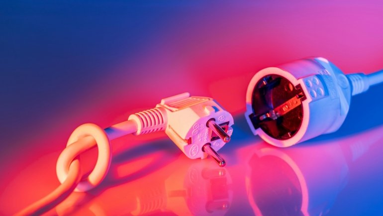 A robust 30 amp power cord safely connected to a travel trailer at a campsite, highlighting reliable electrical power for RVs and outdoor adventures.