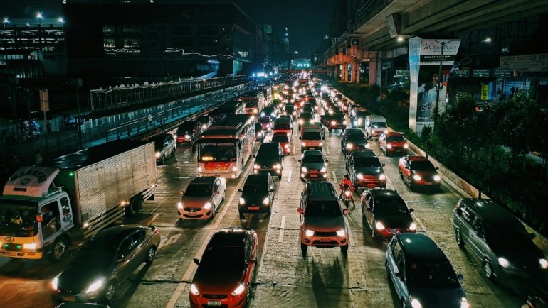 A well-lit Pioneer Travel Plaza at night on a busy highway, featuring multiple fuel pumps, various cars, and commercial trucks, symbolizing a modern, full-service hub for drivers to refuel, rest, and recharge.