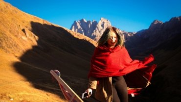 Woman styling hair with travel hot rollers in a hotel room, achieving voluminous and long-lasting curls for effortless travel beauty.