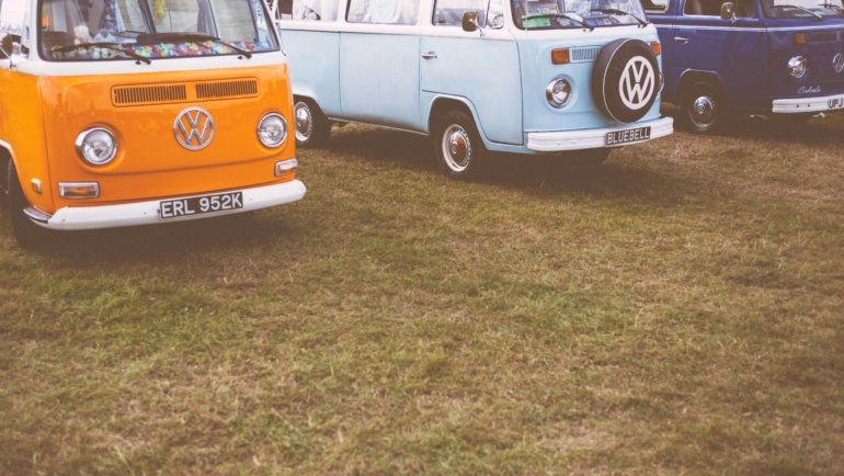 2012 Holiday Rambler Traveler motorhome brochure open on a table with an RV parked in a scenic natural setting, highlighting detailed floor plans and specifications for classic road trip planning.