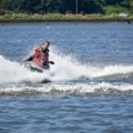 A rider expertly steers a personal watercraft (PWC) through a dynamic turn on the water, demonstrating precise control, throttle application, and body lean crucial for safe navigation.