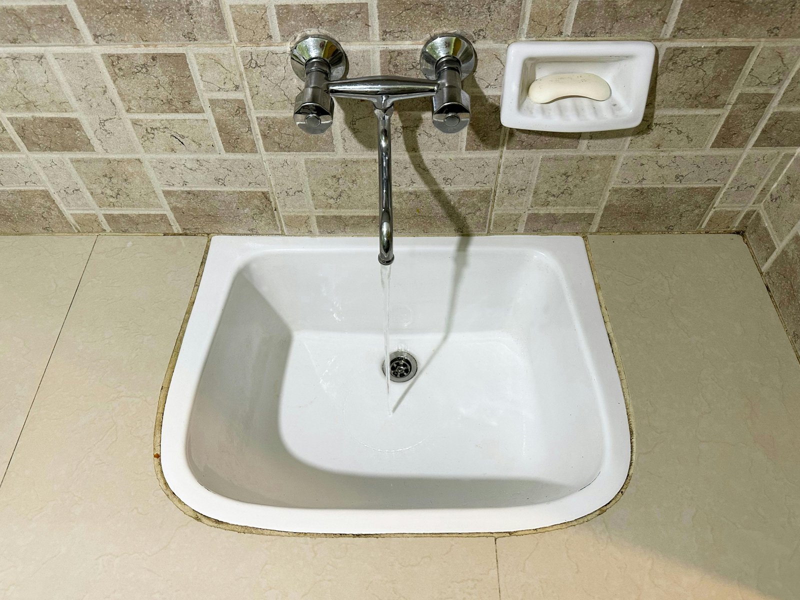 Traveler hand-washing a shirt in a hotel sink with travel size washing powder, illustrating easy laundry solutions for packing light and staying fresh on trips.