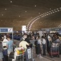 Crowded terminal at Boston Logan International Airport during peak holiday travel season, depicting travelers, luggage, and the busy atmosphere associated with potential delays.