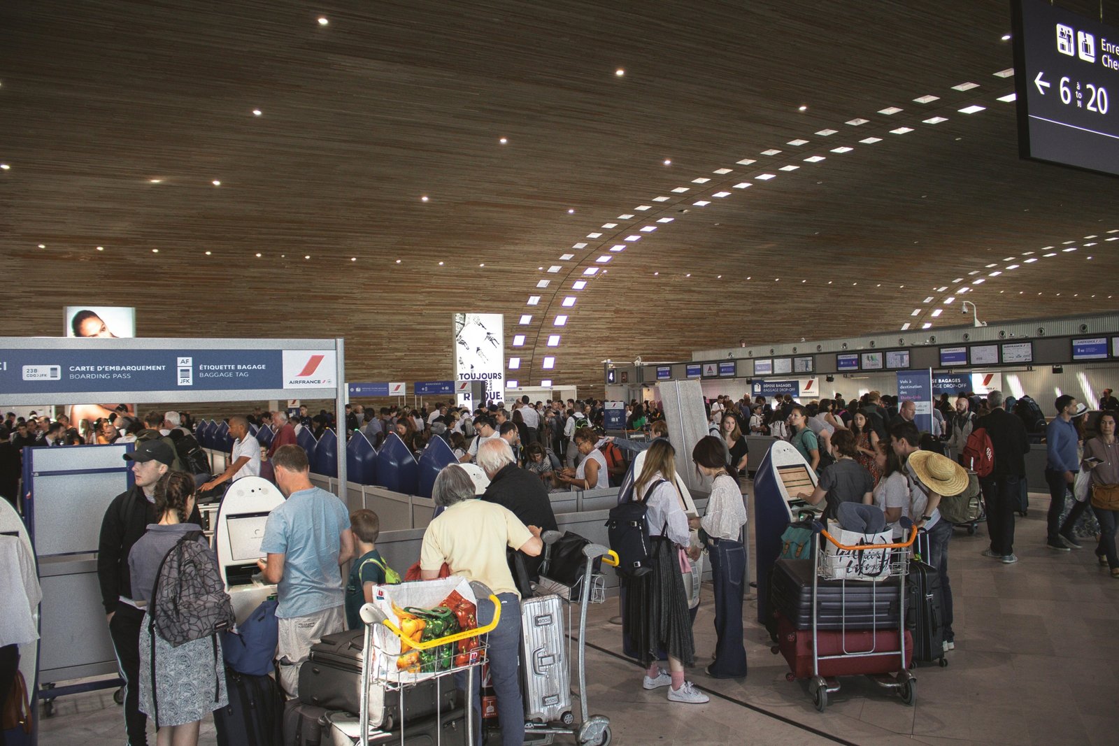 Crowded terminal at Boston Logan International Airport during peak holiday travel season, depicting travelers, luggage, and the busy atmosphere associated with potential delays.