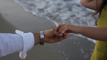 Happy couple enjoying a scenic vacation destination, wearing durable travel wedding rings, symbolizing peace of mind and carefree adventure.