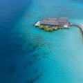 Luxury travel blog holiday inspiration: Stunning turquoise waters and white sandy beach featuring a luxurious overwater bungalow resort, epitomizing a serene tropical paradise getaway.