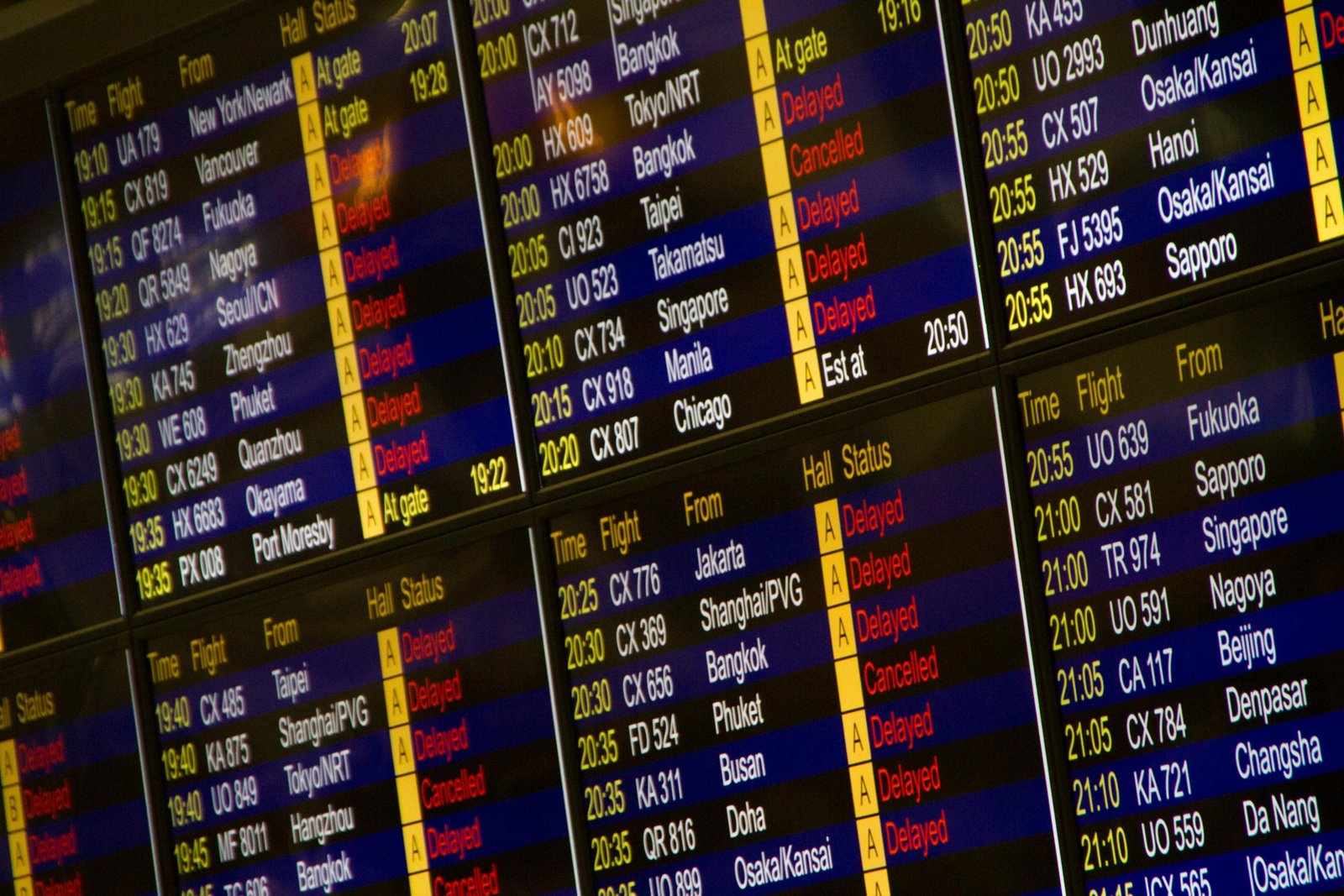 Frustrated passengers at a European airport departure terminal, looking at a board filled with cancelled and delayed flights due to a Belgium air traffic control strike, highlighting travel disruption.