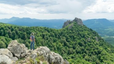 A solo traveler standing confidently, looking at a vibrant cultural landscape, symbolizing the freedom, self-discovery, and authentic connections fostered by independent travel and communities like CreativeCultureTribe.