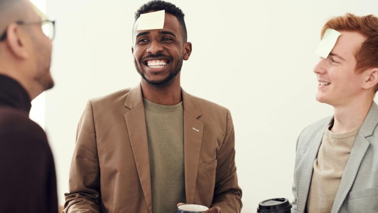 Diverse team collaborating happily at a corporate retreat, showcasing positive team travel spirit and enhanced employee morale.