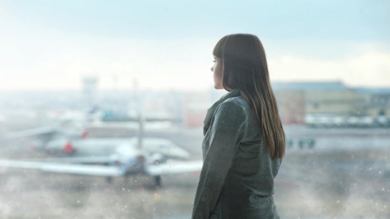Bereavement travel: A pensive individual at an airport, reflecting on a difficult journey during a family emergency, illustrating the context for understanding Southwest Airlines' flexible policies.