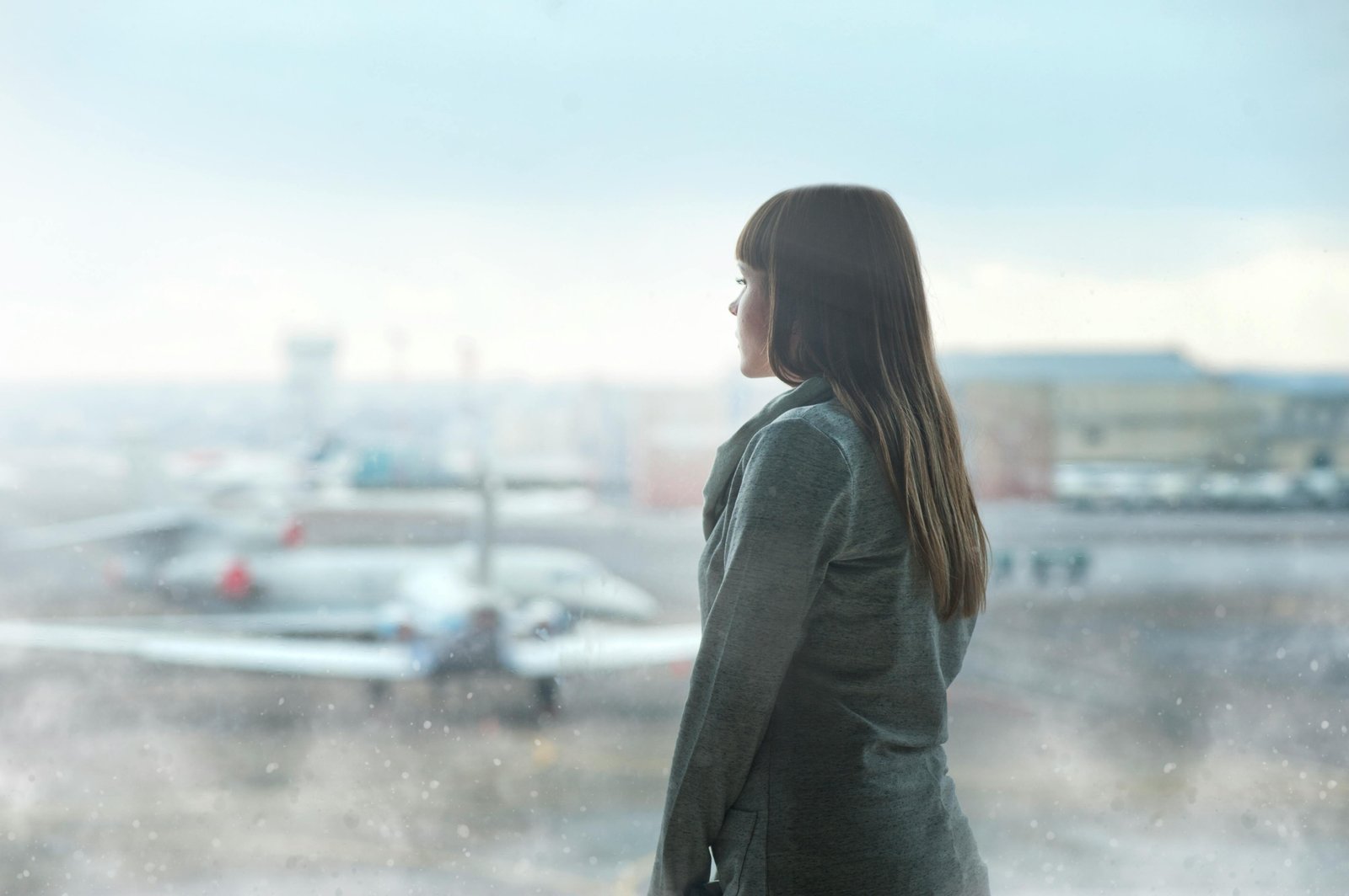 Bereavement travel: A pensive individual at an airport, reflecting on a difficult journey during a family emergency, illustrating the context for understanding Southwest Airlines' flexible policies.