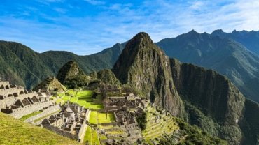 Iconic Machu Picchu vista under a clear blue sky, representing the best time to travel and hike in the Peruvian Andes during the dry season.