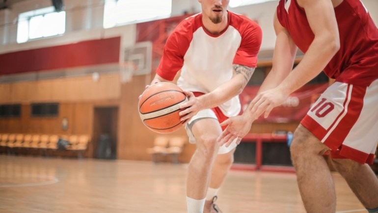Young competitive basketball players in action during a travel team game, emphasizing skill development and the intense commitment of youth club basketball.