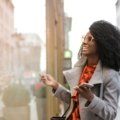 Black traveler confidently using the Martinique Lewis ABC Travel Green Book app on a smartphone to discover safe, inclusive, and welcoming travel experiences with a global community.