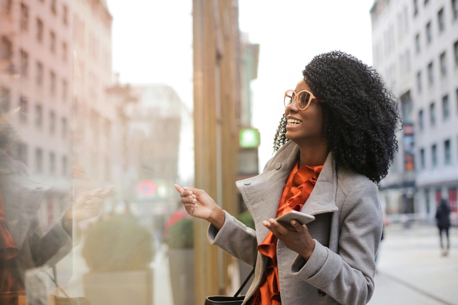 Black traveler confidently using the Martinique Lewis ABC Travel Green Book app on a smartphone to discover safe, inclusive, and welcoming travel experiences with a global community.