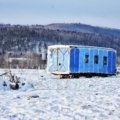 A 4 season travel trailer parked in a snowy mountain landscape, illustrating comfortable winter camping and year-round adventure capabilities of an all-season RV with enhanced insulation.
