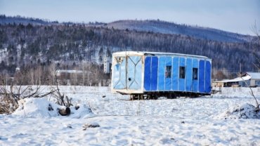 A 4 season travel trailer parked in a snowy mountain landscape, illustrating comfortable winter camping and year-round adventure capabilities of an all-season RV with enhanced insulation.