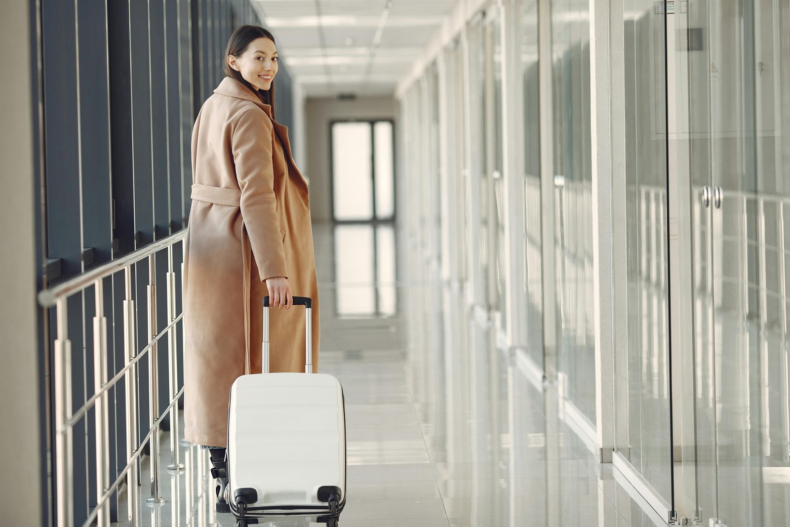Modern traveler with sleek, durable luggage in an airport, representing smart strategies to find Away travel coupon codes and save on premium luggage.