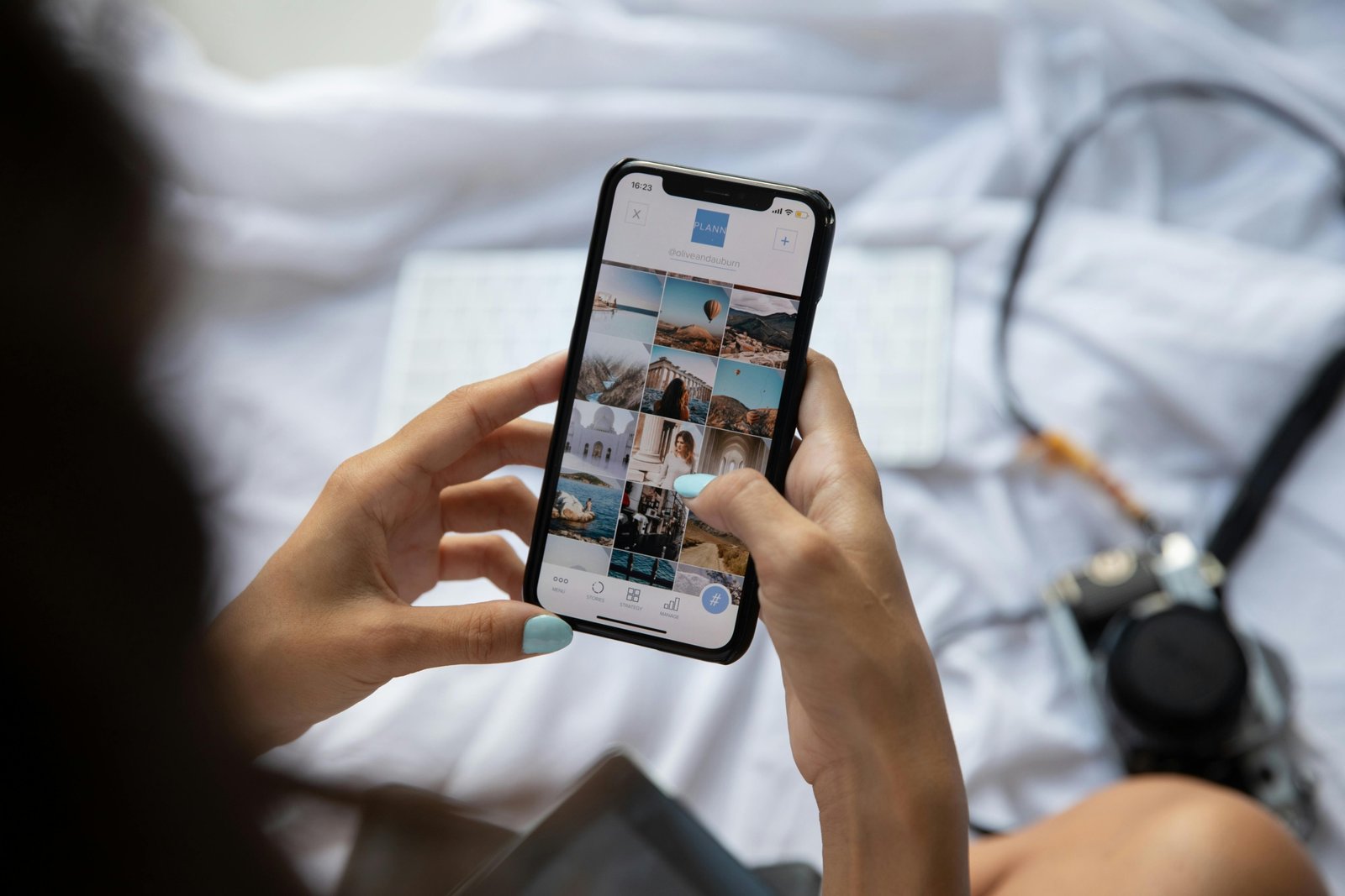 Happy traveler posting on social media using a smartphone with various travel emojis like airplane, beach, and camera, depicting digital trip sharing.