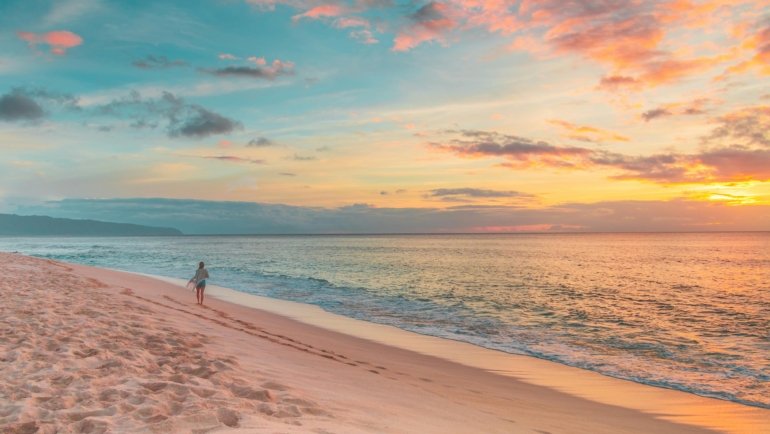 Travel nurse enjoying a beautiful Hawaiian beach sunset, illustrating ideal work-life balance and a dream tropical lifestyle.
