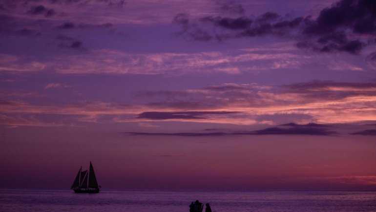 Breathtaking sunset view over the white-sand beach and clear waters of Clearwater Travel Resort in Florida, perfect for a luxurious family vacation.
