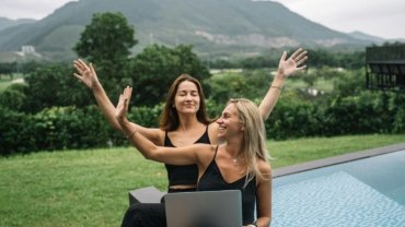 Digital nomad working on a laptop in a beautiful scenic travel destination, symbolizing remote work and making money while traveling.