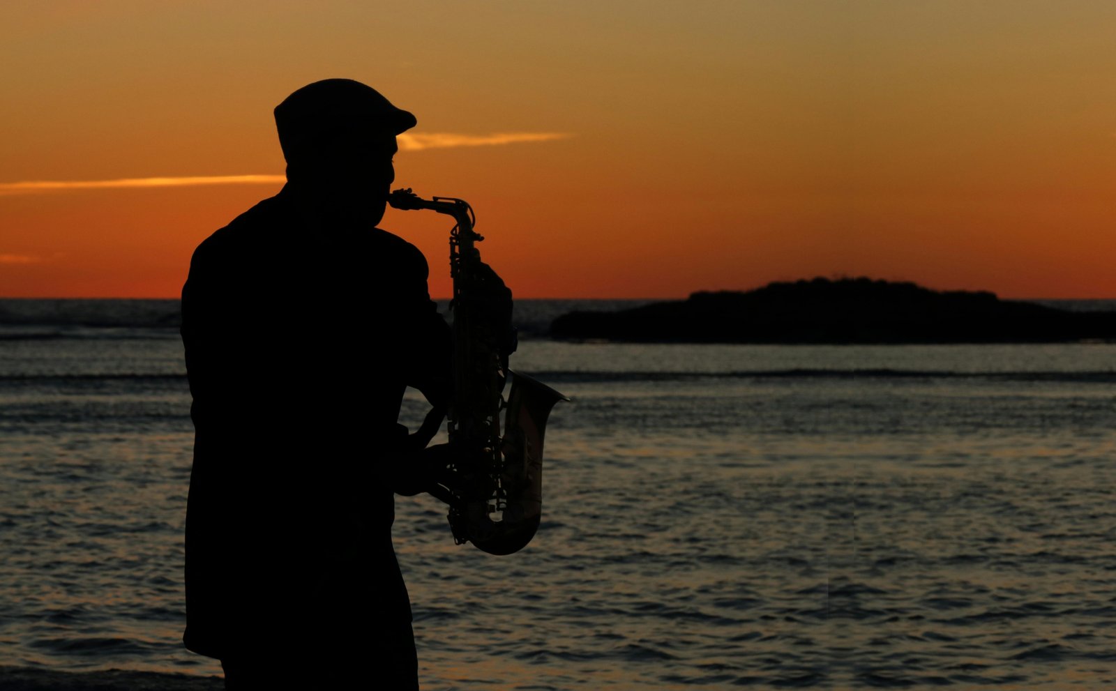 Musician happily playing a portable travel saxophone in a beautiful outdoor landscape, emphasizing freedom and convenient music practice while traveling.