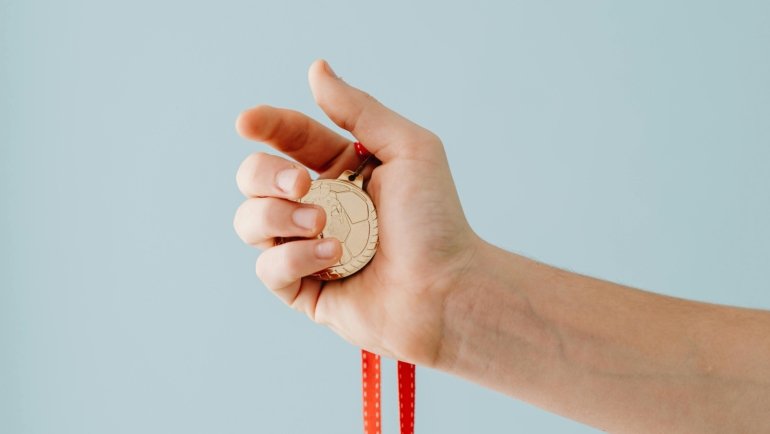 A traveler's hand holding a St. Christopher medal, symbolizing the patron saint of travel's protection for a safe and spiritually guided journey.