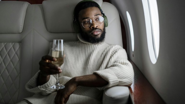 Soft, portable travel blanket providing warmth and comfort to a person relaxing on an airplane seat, emphasizing its benefits for long flights and travel.