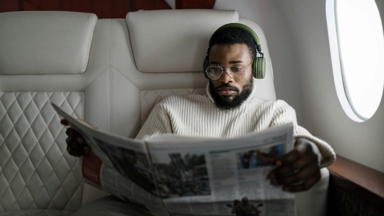 Person sleeping soundly with a comfortable ergonomic travel neck pillow on a plane, highlighting the importance of quality travel cushions for support and relaxation during long journeys.