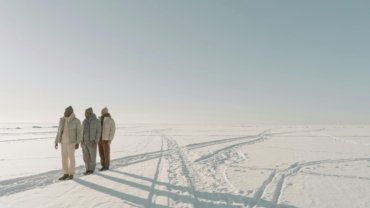 A stylish modern adventurer with a premium backpack overlooks a majestic natural landscape, symbolizing Trevor Morrow's approved authentic and adventurous travel.